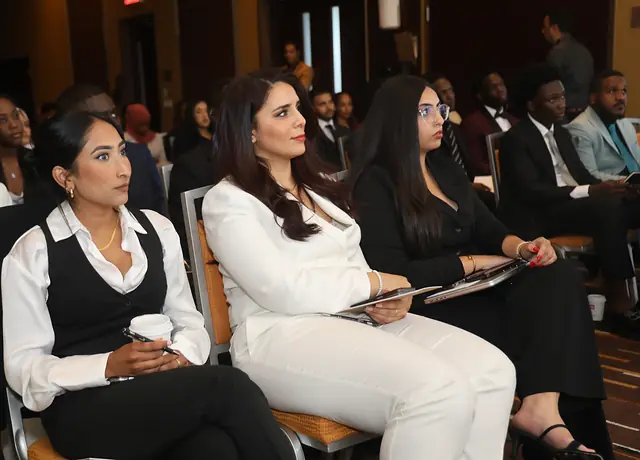 Public attentif, en tenue élégante, lors d'une conférence